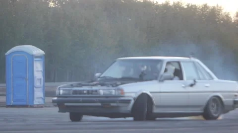 Grey car drifts around corner while spark plate ignites. Stock Footage 59762217