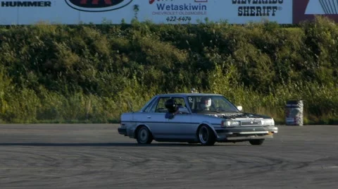 Grey car with flat tire rounds corner on closed drifting track. Stock Footage 59747409
