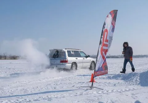 Grey car started driving on snow-covered highway Stock Photos
