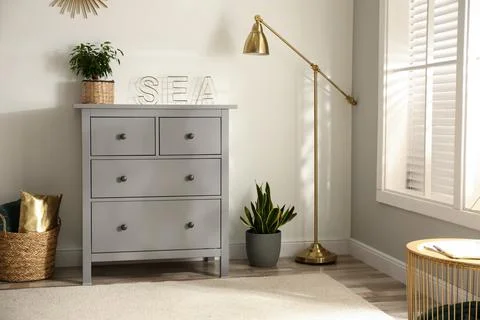Grey chest of drawers in stylish room interior Stock Photos