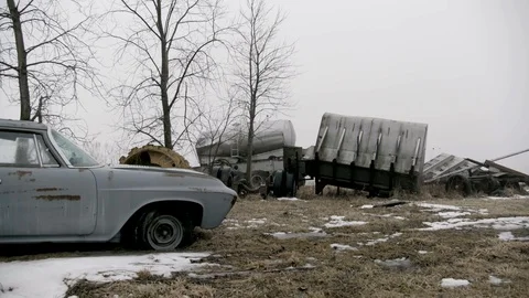 Grey classic station wagon car and trucks abandoned in snow covered field Stock Footage 89945112
