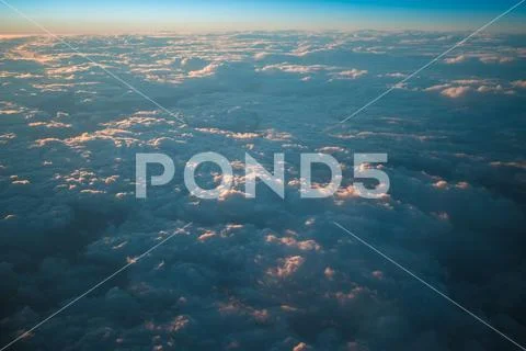 The grey clouds against the background of sunset. View from airplane Stock Photos