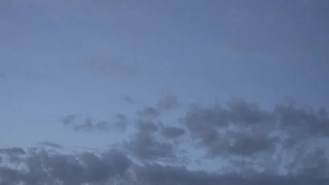 Grey Clouds Drifting Across a Blue Evening Sky at Dusk Stock Footage 336092597