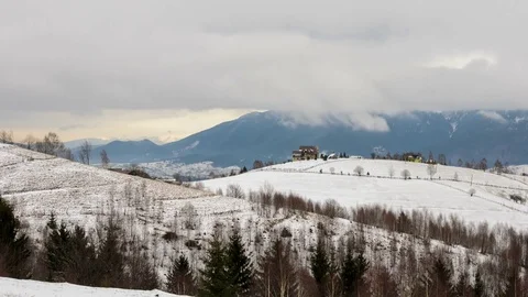 Grey clouds over mountains and isolated houses in winter. Stock Footage 79554692
