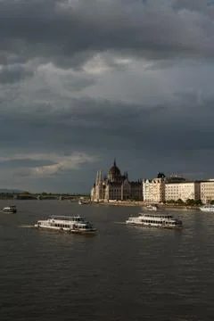 The grey clouds over River Danube full of driving boats. Landscape view of Stock Photos