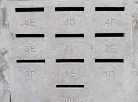 A grey concrete panel featuring numbered mail slots and empty space for text  Stock-Fotos