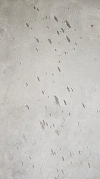 Grey concrete wall texture with dark spots and weathered stone surface Stock Photos