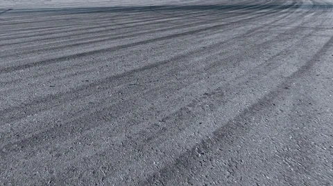 Grey dry asphalt road at an angle all covered with black stripes traces of Stock Footage 125804979