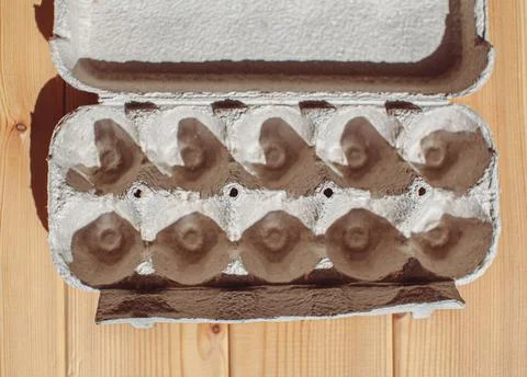Grey egg carton without eggs on white background. Stock Photos