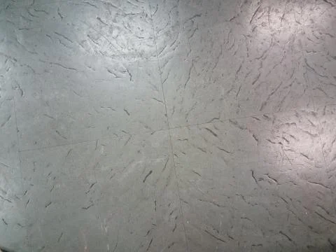 Grey floor tiles with gouges and scratches Stock Photos