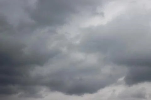 Grey fluffy clouds on cloudy sky Stock Photos