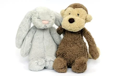 A grey fluffy rabbit soft toy and brown fluffy monkey soft toy Stock Photos