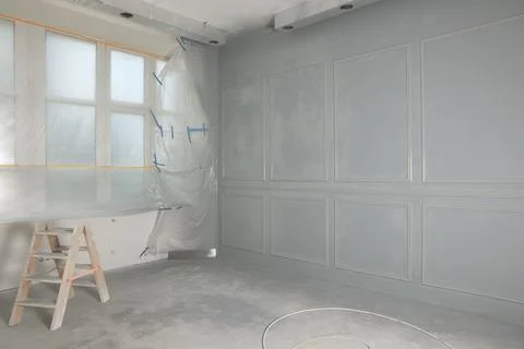 Grey fresh painted wall with frames near window Stock Photos