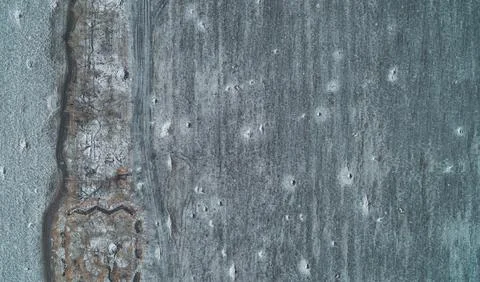 Grey frozen soil texture with rough pitted surface and frost, abstract Stock Photos