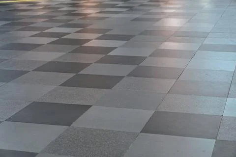 Grey granite tile checkered pattern on modern building floor surface Stock Photos