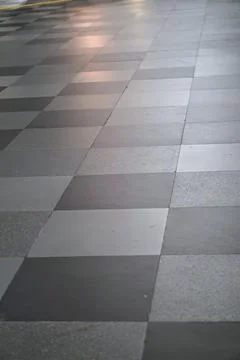 Grey granite tile checkered pattern on modern building floor surface Stock Photos