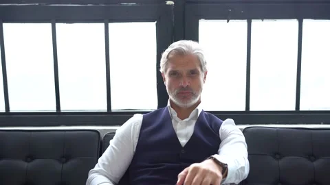 Grey-haired elegant man sitting on couch. Stock Footage 140644555
