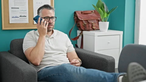 Grey-haired man business worker sending voice message by smartphone smiling.. Video stock 246992567