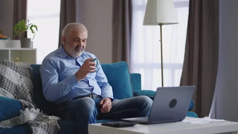 Grey haired man is chatting by video call in laptop from home, online Stock Footage 153516779