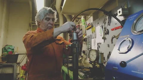 Grey haired man repairs important Natig Aliev tanker details Stock Footage 133036691