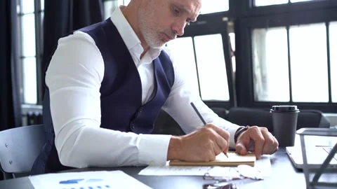 Grey-haired man working on a laptop. Serious mature man in elegant suit typing Stock Footage 140642820
