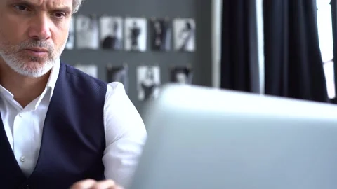 Grey-haired man working on a laptop. Serious mature man in elegant suit typing Stock Footage 140642907