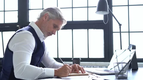 Grey-haired man working on a laptop. Serious mature man in elegant suit typing Stock Footage 140642951