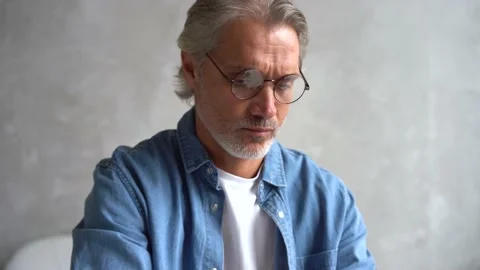 Grey-haired Mature handsome man typing on laptop while working at home. Stock Footage 141192328