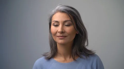 Grey-Haired Middle Aged Asian Woman With A Mysterious Expression On her Face Stock Footage 126236743