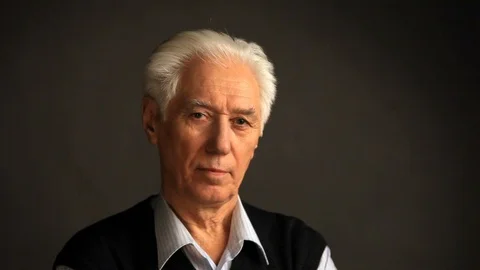 Grey-haired senior man puts on glasses Stock Footage 98719126