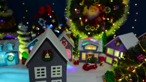 A grey house rotating in front of a large decorated Christmas town Stock Footage 319895870