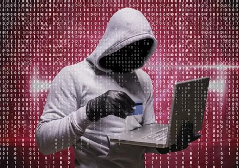 Grey jumper hacker with the computer and the credit card 스톡 사진