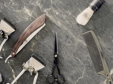 On a grey marble surface are old barber tools. top view. flat lay. Stock Photos
