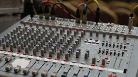 A grey mixing board with many knobs and buttons Stock Photos