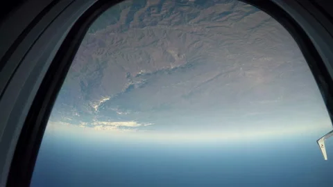 A grey mountain range with snow-capped peaks from the height of an aircraft Stock Footage 129692847