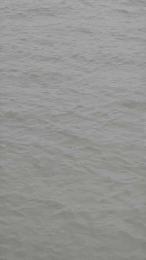 Grey muddy sea water surface with ripples waves murky lake 4k vertical vid 库存影片 265584798