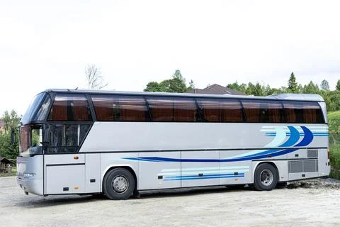 Grey passenger bus viewed from the side standing on a parking lot. Public t.. Stock Photos