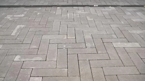 Grey paving stones in a herringbone pattern on an urban walkway. 스톡 사진