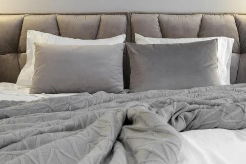Grey pillows knitted blanket bed Stock Photos