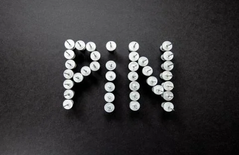 Grey pins on a black background close up Stock Photos