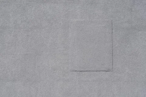 Grey plaster wall texture with rectangular repair patch 写真素材