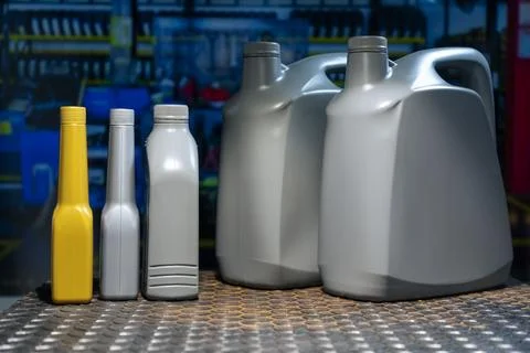Grey plastic canister with car engine oil on a metal table in a workshop or.. 库存照片