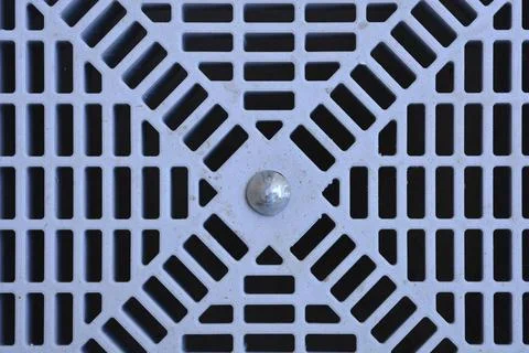 Grey plastic drainage grate with geometric grid pattern close up Stock Photos