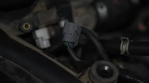 Grey plastic electrical sensor plug connector inside car engine bay. Stock Footage 344231443