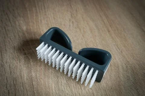 Grey plastic nail manicure brush isolated on wooden surface Foto stock