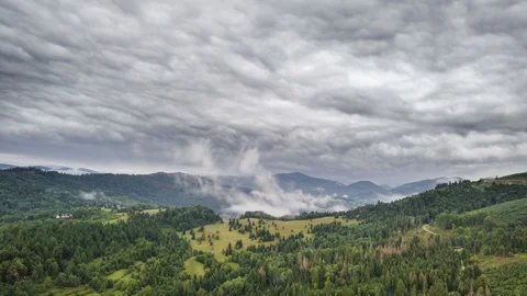 Grey rainy clouds moving over green landscape Aerial Time lapse Stock Footage 94202212