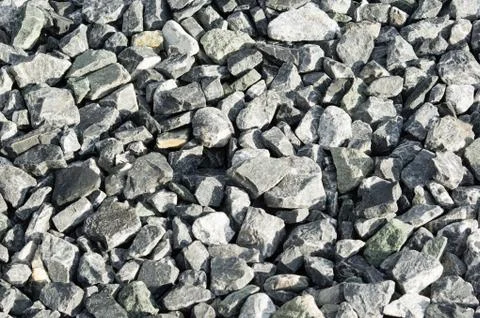 Grey rocks in the evening light. Pavement for laying asphalt. Stock Photos