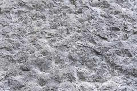 Grey rough stone wall texture background coarse relief rock surface Stock Photos
