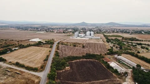 Grey Silos Wheat Bread Production Plant Orbit from Far Away Rural Village in Stock Footage 237356480