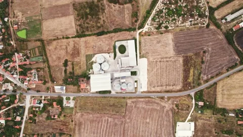 Grey Silos Wheat Bread Production Plant Descend from High Above Rural Village in Stock Footage 237356983